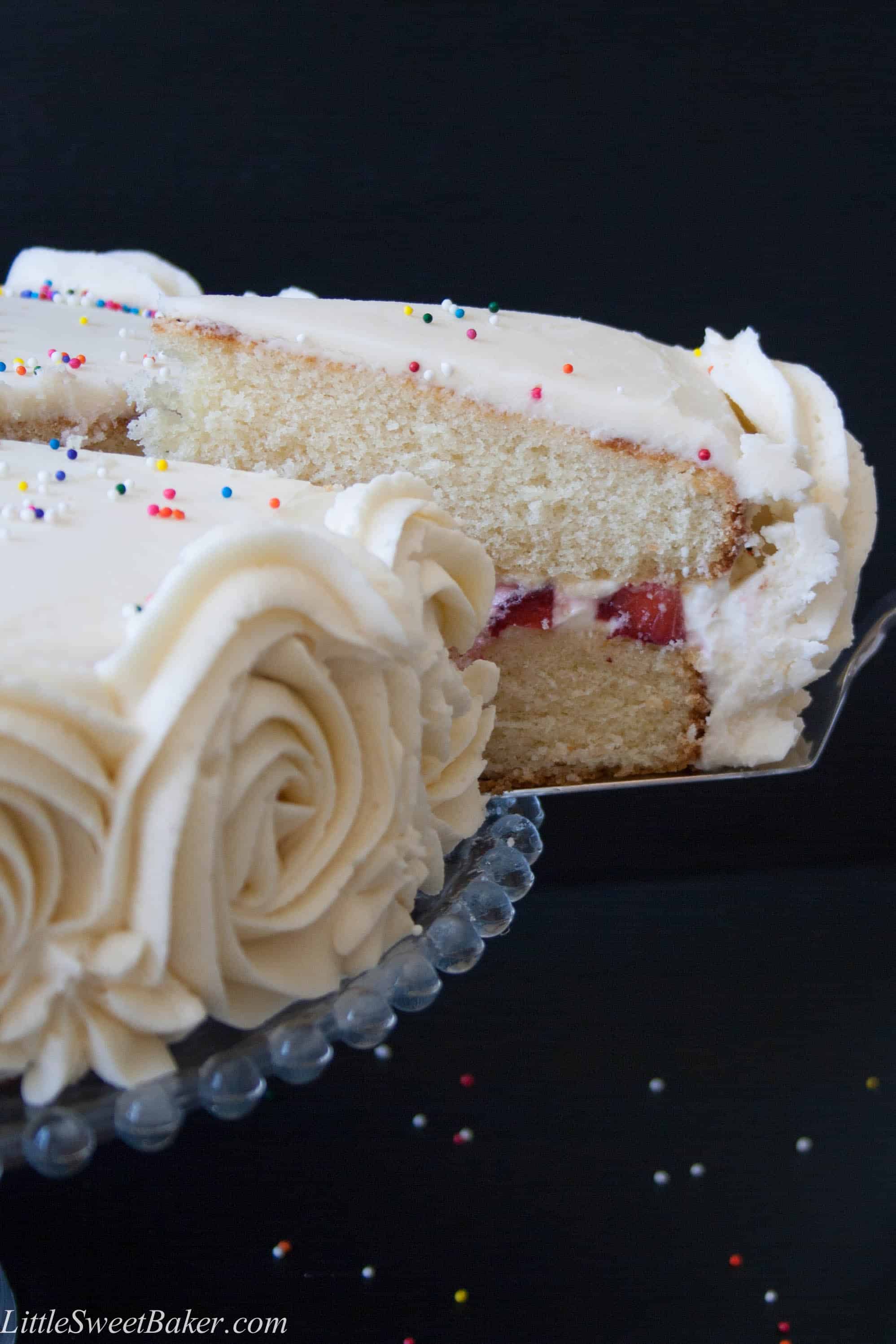 Moist and fluffy vanilla cake with strawberries and cream filling, surrounded with vanilla buttercream.